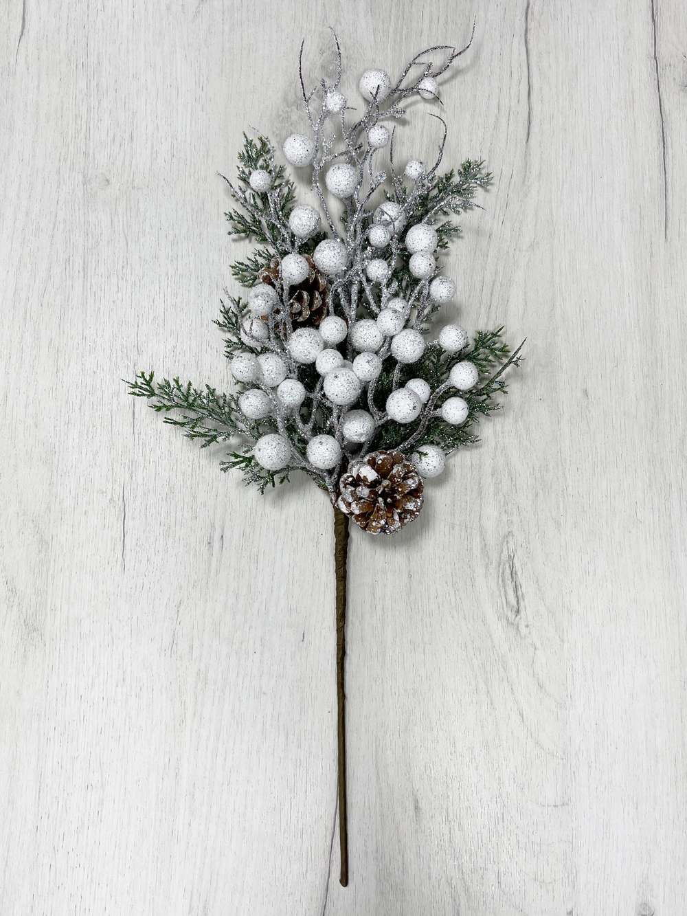 Изображение товара Ветка еловая с белыми ягодами и шишками 50 см заснеженная в блестках
